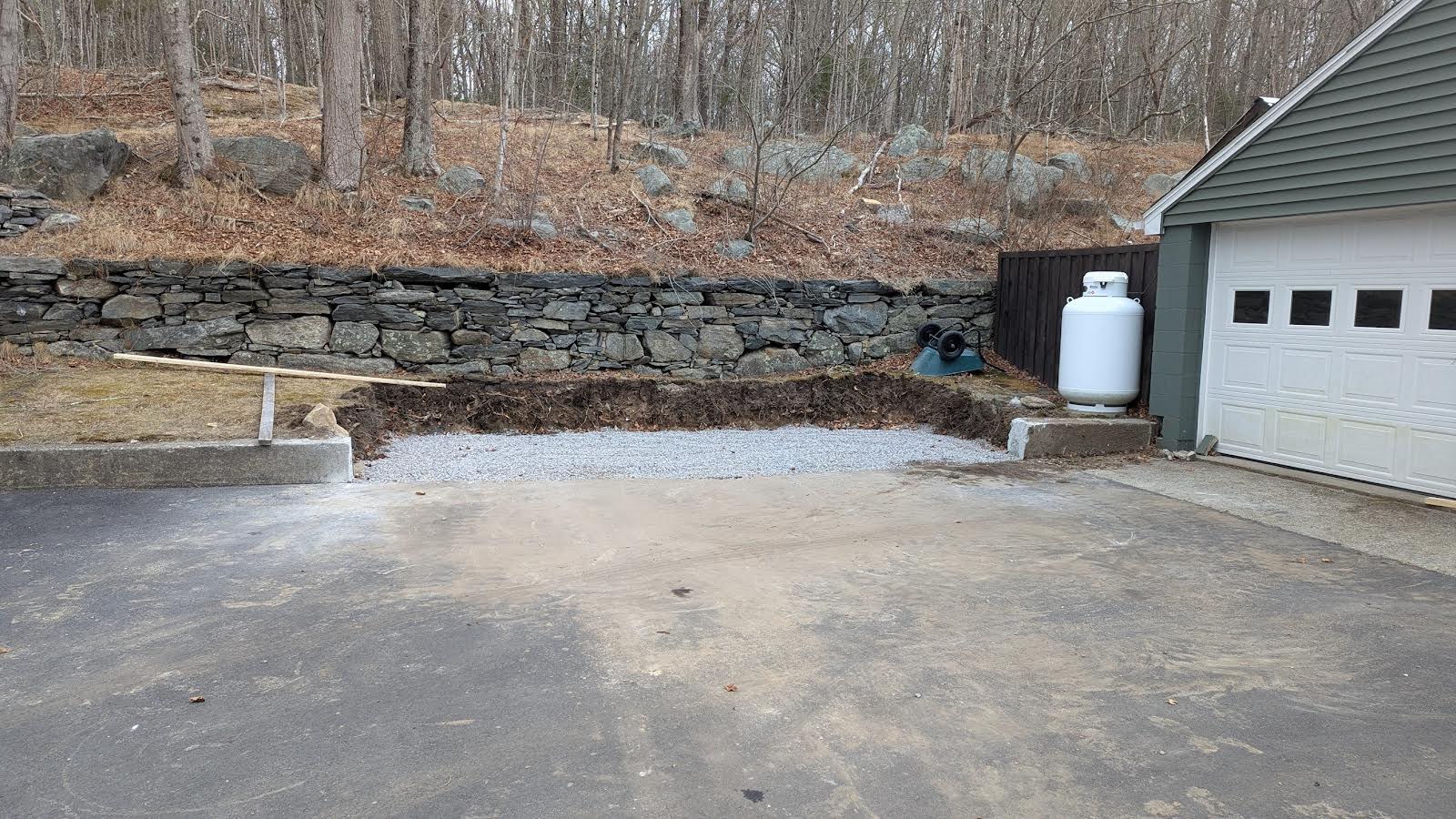 Driveway excavation with stone retaining wall