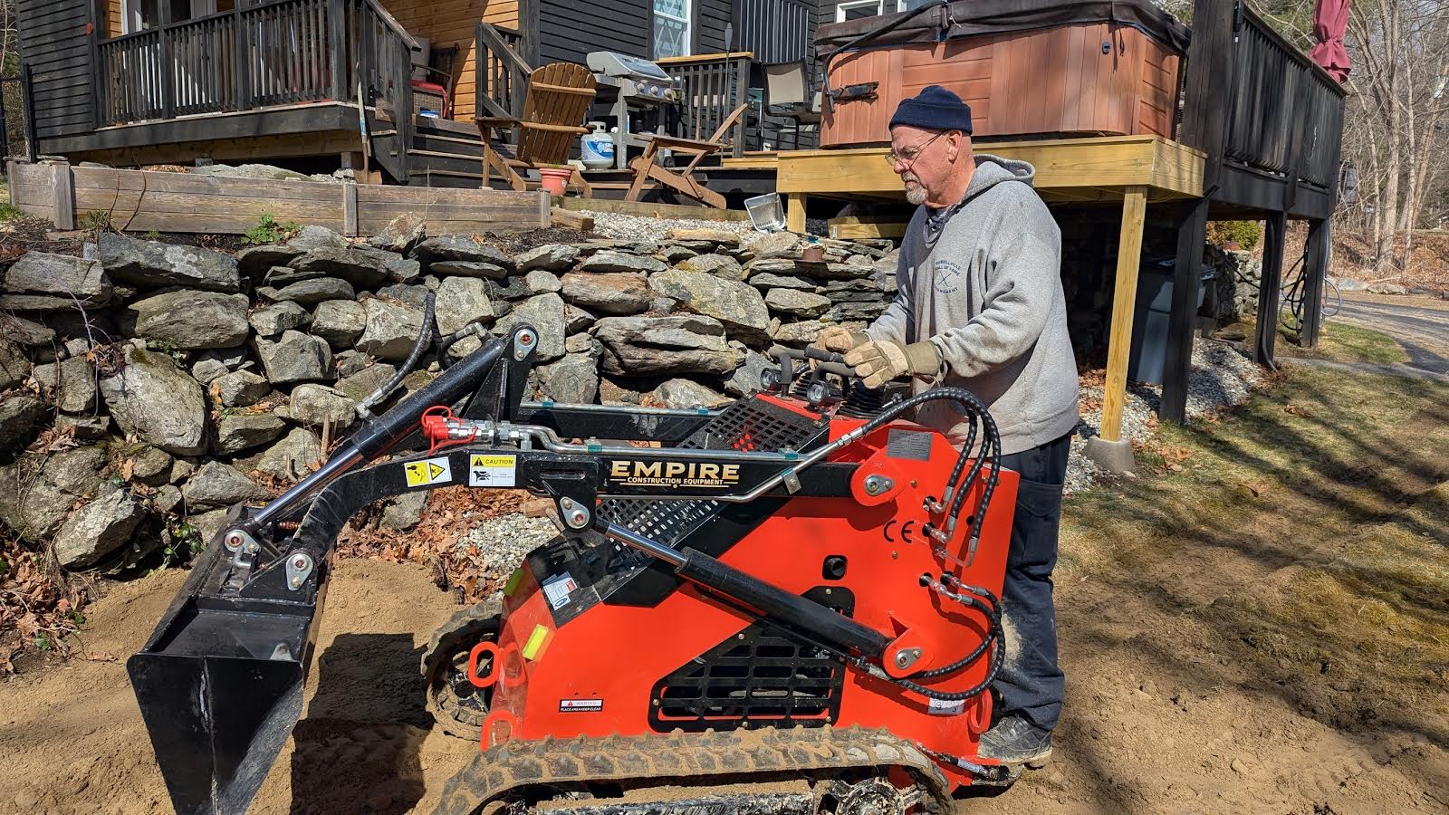 Operator using compact track loader for landscaping work