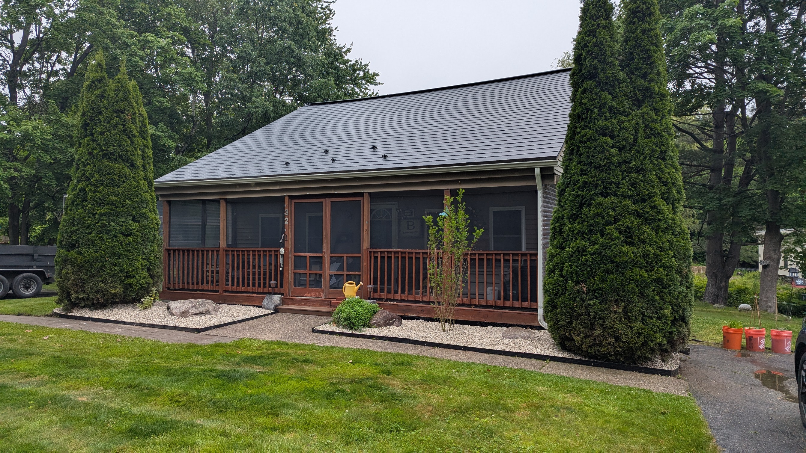 Completed residential landscaping with gravel beds and arborvitae trees
