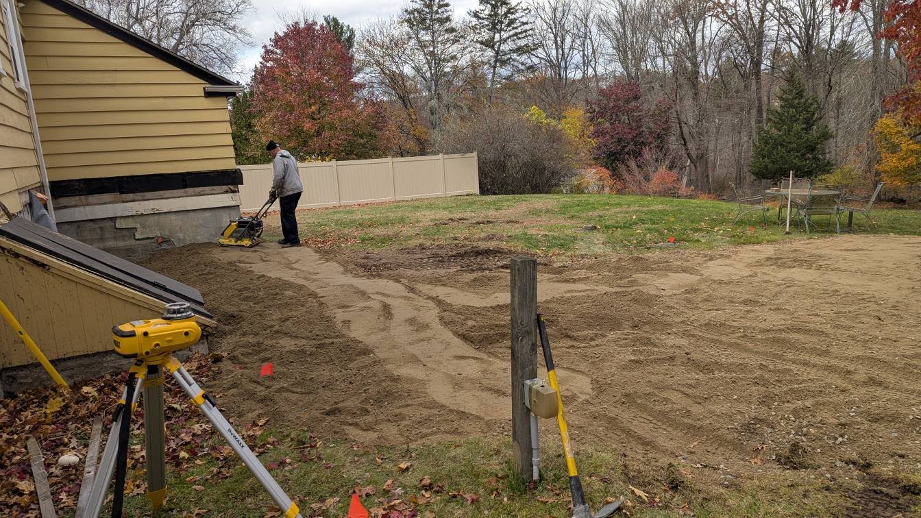 Professional grading and soil compaction work on residential property