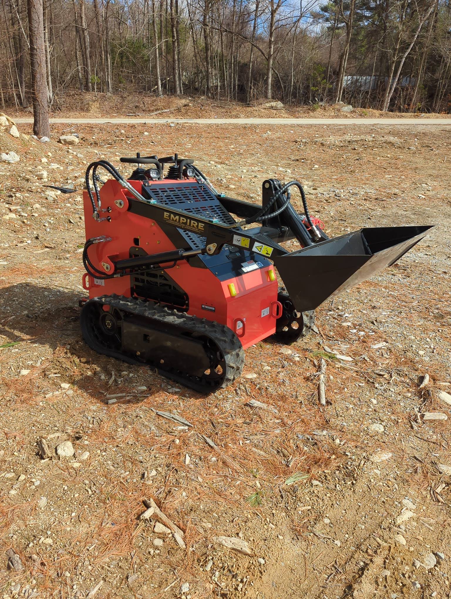 Red and black Empire tracked mini loader with bucket attachment
